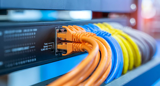 Colorful network cables connected to a server rack, illustrating efficient data transfer solutions with organized wiring.